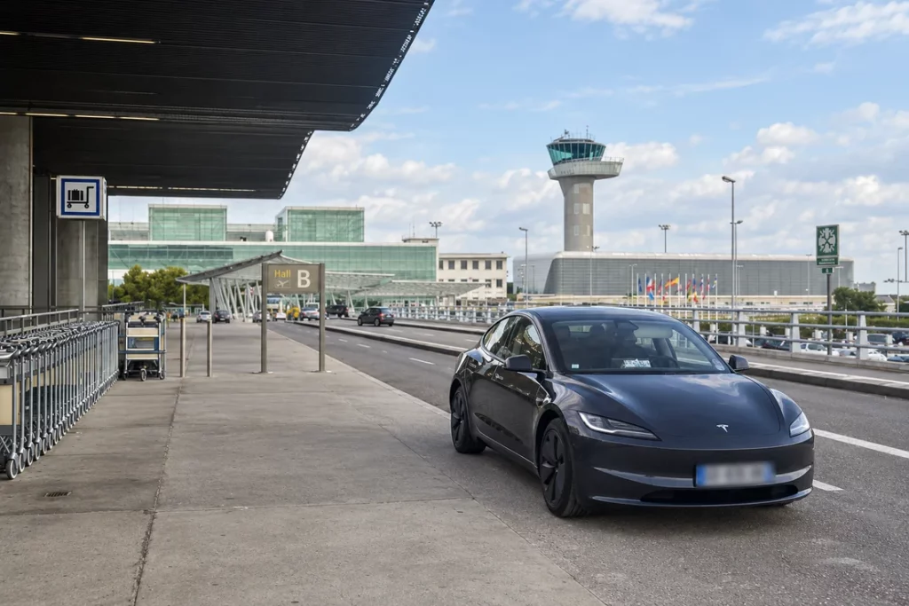 Tesla graphite devant le terminal et la tour de contrôle de l’aéroport de Bordeaux-Mérignac.